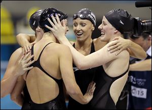 United States' Shannon Vreeland, left, and Missy Franklin, right, embrace Allison Schmitt, foreground, and Dana Vollmer, center, after they won an Olympic gold in the women's 4x200-meter freestyle relay.
