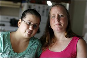 Machelle Moreno and her daughter Angela, 19, pose for a portrait in the kitchen of their home in West Toledo. 