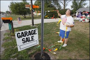 Tim Hahns of Paulding, Ohio, hangs colorful ribbons to draw attention to his garage sale Thursday as part of the World's Longest Yard Sale. 'We've done this for the last five years,' he said. 'It's a blast.'