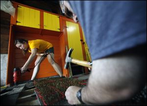Alyssa Brown wields a drill as Michael Gammo pounds symbolic nails for a Wallenberg display to be shown at the University of Toledo’s Carlson Library. Ms. Brown and Mr. Gammo are students at UT.