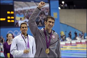 United States' gold medallist Michael Phelps, front, walks with South Africa's silver medallist Chad le Clos behind him after the medal ceremony for the men's 100-meter butterfly swimming final at the Aquatics Centre in the Olympic Park during the 2012 Summer Olympics in London on Friday.