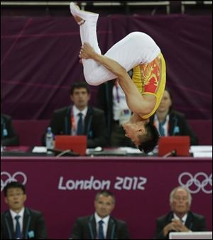 Judges watch the trampoline performance of gold medallist Dong Dong of China at the 2012 Summer Olympics on Friday.
