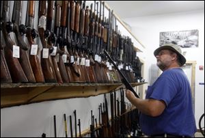 Ryan Brown of Cleveland examines a gun at Cleland's Outdoor World, one of the oldest dealers in the Toledo area.