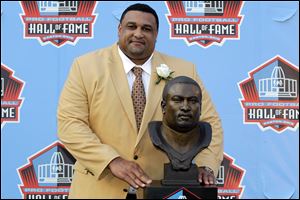 Former Saints lineman Willie Roaf poses with his bust that will sit inside the NFL Hall of Fame in Canton.
