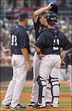 Mud Hens pitcher Casey Crosby talks with pitching coach A.J. Sager and catcher Bryan Holaday in the fourth inning.