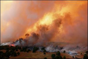 Flames burn near Highway 48 and HW 38 junction east of Drumright, Okla., on Saturday. Emergency management officials have ordered evacuations of homes in several areas as wildfires burn across the state. The Oklahoma Department of Emergency Services says no injuries have been reported. 
