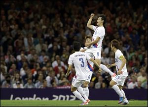 South Korea's Ji Dong-won (9) celebrates his goal with teammates Yun Suk-young (3), Koo Ja-cheol (13), and Ki Sung-yueng (6).