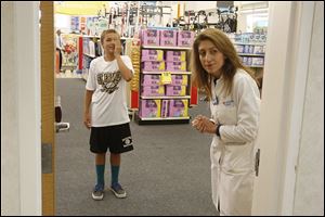 Mary Hull, right, a family nurse practitioner, gives an eye test to Blake Howard, 12, at the MinuteClinic at CVS Pharmacy in Arcadia, Calif. There are more than 1,350 of these in-store clinics nationwide.