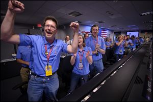 Mars Science Laboratory GDS Engineer Rob Sweet, left, reacts along with other MSL team members after the rover Curiosity successfully landed on Mars, Sunday.