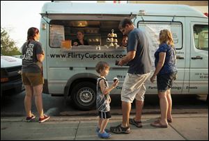 Customers make selections from the Flirty Cupcakes truck in Chicago. Owner Tiffany Kurtz obtained her first truck in May, 2010, and added a second seven months later. She now has a store as well. 