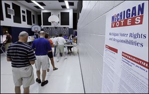 Voters wait to cast ballots at the Monroe Family YMCA on a variety of candidates and issues, including levies for the county historical museum, county library system, and support for senior citizens’ programs.