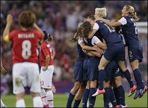 United States players celebrate today winning the women's soccer gold medal match as Japan's Aya Miyama, left, reacts at the 2012 Summer Olympics.