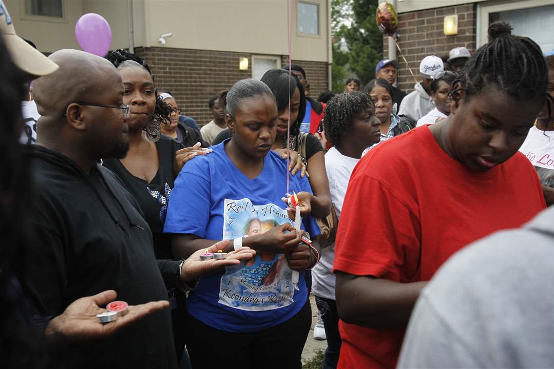 Quentorria-Snowden-center-holds-a-candle-during