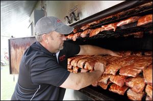 Bill Ball, owner of Mojo's Rib Shack in Coolville, Ohio, near the West Virginia border, loads his smoker with 144 racks of ribs. 