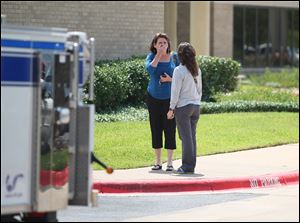 A woman reacts outside of the College Station Medical Center, Monday, in College Station, Texas where five victims were brought, following a shooting near the Texas A&M campus. A gunman and a law enforcement officer were among three people killed Monday in a shooting near a Texas university campus, police said.