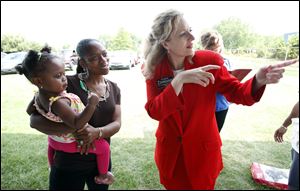 Angela Zimmann, the Democratic challenger to U.S. Rep. Bob Latta, talks with Maria Bass, who is holding her 20-month-old daughter, Imari, at the UAW picnic.