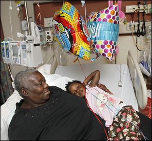 Shooting victim Leondra Hooks, 2, with her great-grandmother, Naomi Reed, at St. Vincent Mercy Medical Center in Toledo.