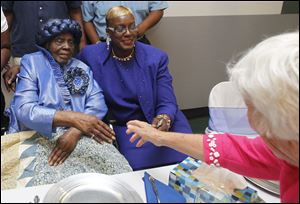 Bell Zora Weatherspoon, left, with daughter Ruby Weatherspoon, greets a friend at her 100th birthday party at Toledo’s Flory Gardens Senior Center.