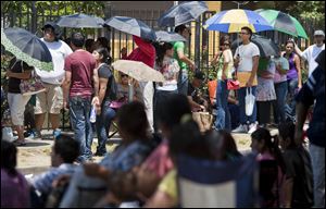 Hundreds of illegal immigrants counting on the DREAM Act passing wait in line Tuesday to get a passport or any other kind of assistance outside the Mexican Consulate in Houston.