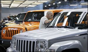 Newly assembled Jeep vehicles are inspected by a worker at the Toledo Assembly complex.