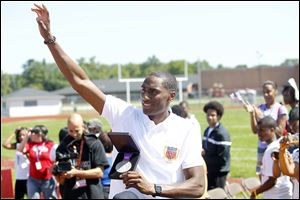 Erik Kynard, Jr., holds his silver medal while being driven in a parade through the crowd of fans during a parade and welcome home Olympics ceremony sponsored by Toledo Public Schools at the Rogers High School football field on August 18, 2012.