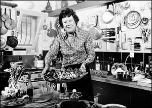 This 1978 file photo shows American television chef Julia Child showing a salade nicoise she prepared in the kitchen of her vacation home in Grasse, southern France. 