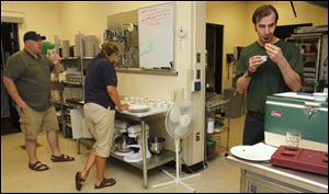 Firefighter Chad Lowry, left, Owens chef Gretchen Fayerweather, center, and Burger Bar owner Tony House judge the offerings.