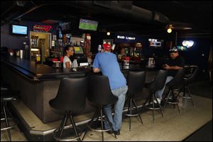 Brew-Ha's bartender Aimee Wallace serves customers in the bar on Telegraph Road. Stephanie Berman, a manager, says that the tavern has been able to do well. Still, she says she hopes that new developments are on the horizon to rejuvenate the area. 