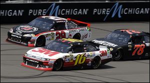 Greg Biffle (16), Kevin Harvick (29), and Regan Smith (78) battle for position during the NASCAR Sprint Cup Pure Michigan 400 auto race at Michigan International Speedway today.