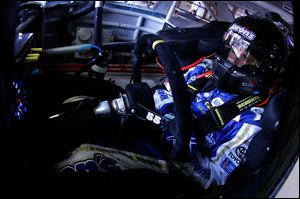 Mark Martin, who won the pole position, sits in his car watching practice at MIS. Dale Earnhardt, Jr., will start at the back of the field after he was forced to use a different car following a crash on Saturday.