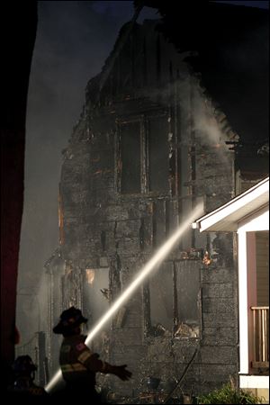 Firefighters work to put out a fire at 149 Oak St. in Rossford, Sunday.