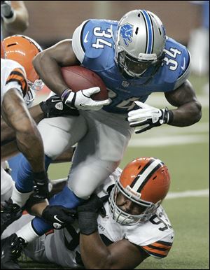 Browns rookie John Hughes, bottom, tries to wrap up the Lions' Keiland Williams. Hughes was a surprising third-round pick.