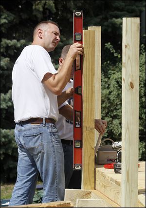 David Shepherd, left, and Keith Bryska of the Columbus-based Navy recruiting office, check a post for level.