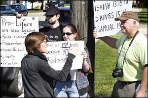Pro-life supporter Savannah Marten, from Toledo, confronts pro-choice supporters Christopher Hill, left, Niki Aktipis, center, and Mark Farris, right, after the 
