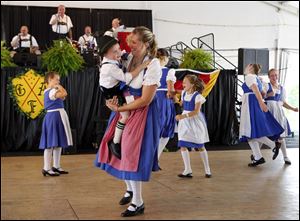 Laurie Remz-Gast of Whitehouse dances with her son Cole Gast, 3, during the German-American Festival at Oak Shade Grove in Oregon. A total of 35,000 visitors are expected to attend the threeday event, at which Ms. Remz-Gast danced Saturday. It offers dancing, music, and German beer and food.