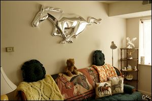The iconic Ford Mustang trademark blazes across her living room wall.