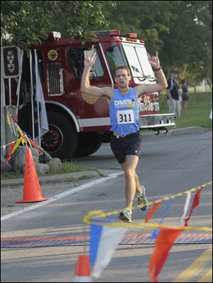 Nick Glover crosses the finish line as the overall first finisher. He was among hundreds participating in Saturday's event.