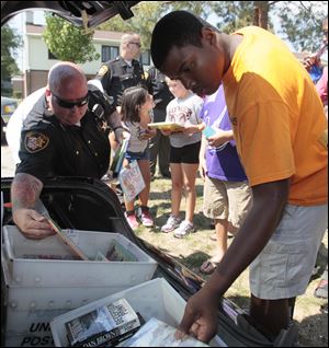 Sheriff’s Deputy Shawn McMahon and Books 4 Buddies founder
L. Touré McCord II distribute some of the volumes.