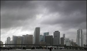 Heavy storm clouds hover over the skyline of downtown Miami as Tropical Storm Isaac's weather bands reach the shore. Forecasters warning it could grow into a dangerous Category 2 hurricane as it nears the northern Gulf Coast.