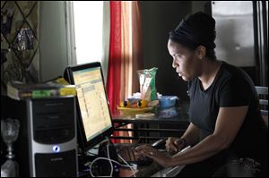 Twila Owens, right, and her son Barack James, left, look at pictures of gang members on Facebook at their Platt Street home where her son Lawrence James, 19, was shot 5 times by home intruders.