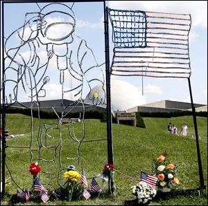 Flowers and flags in front of the museum are memorials to Neil Armstrong. 