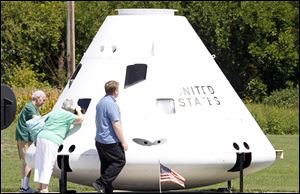 Rex Messick, left, Jackie Messick, and Phillip Messick look at the Apollo command mock-up at the museum.