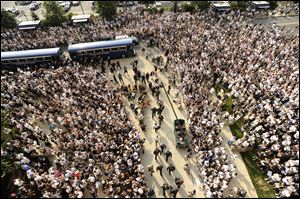 The Penn State football team walks towards Beaver Stadium in State College, Pa., between crowds of people as they arrive for the season opener against Ohio University.
