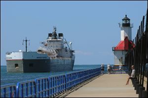 The 630-foot, 19,650-ton barge Manitowoc, operated by the Lower Lakes Transportation Company, passes the St. Joseph Lighthouse as it leaves Lake Michigan and enters the St. Joseph River last month in St. Joseph, Mich. As the drought contributes to a continued drop in the level of Lake Michigan, residents, fishing operators and others who use the harbors and docks in the northwestern Lower Peninsula are facing hazards and hassles.