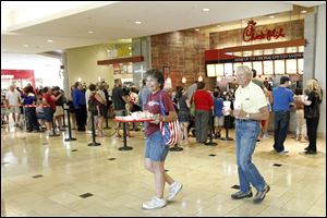 Arline and Forest Sabin carry food from Chick-fil-A in Westfield Franklin Park in support of Dan Cathy, the chain's owner, in August.