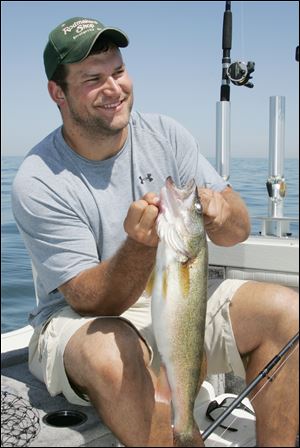 Joe Thomas displays a walleye he took during an outing on Lake Erie, his recreational home away from home.