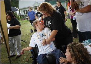 Veronica Taylor, right, stood with her daughter Valerie, 17, Wednesday afternoon during the groundbreaking ceremony at the Taylor family home in Sylvania.