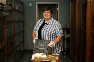 Sister Sandra Rutkowski displays one of the Bibles that will be on display in October's King James Bible exhibit at the Duns Scotus Library at Lourdes University in Sylvania. The university has a number of historic texts in its special collection at the library.  