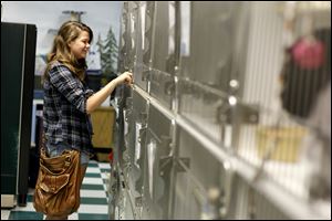 Erica Alford, 19, looks for a kitten at Paws and Whiskers Cat Shelter. The nonprofit shelter in Toledo can comfortably accommodate 65 cats, but has 90 up for adoption and is running several adoption specials. 