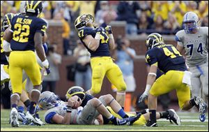Michigan's Jake Ryan (47) celebrates after stopping Air Force's Connor Dietz late in the fourth quarter. The defense had to make one final stand to secure the victory.